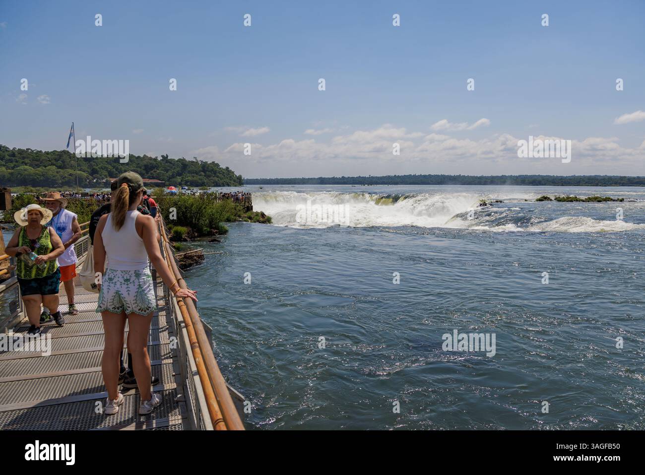 Puerto Iguazu, Misiones, Argentina - April 5th, 2025: Tourists watching the Devil's Throat waterfall at Iguazu Falls. Stock Photo