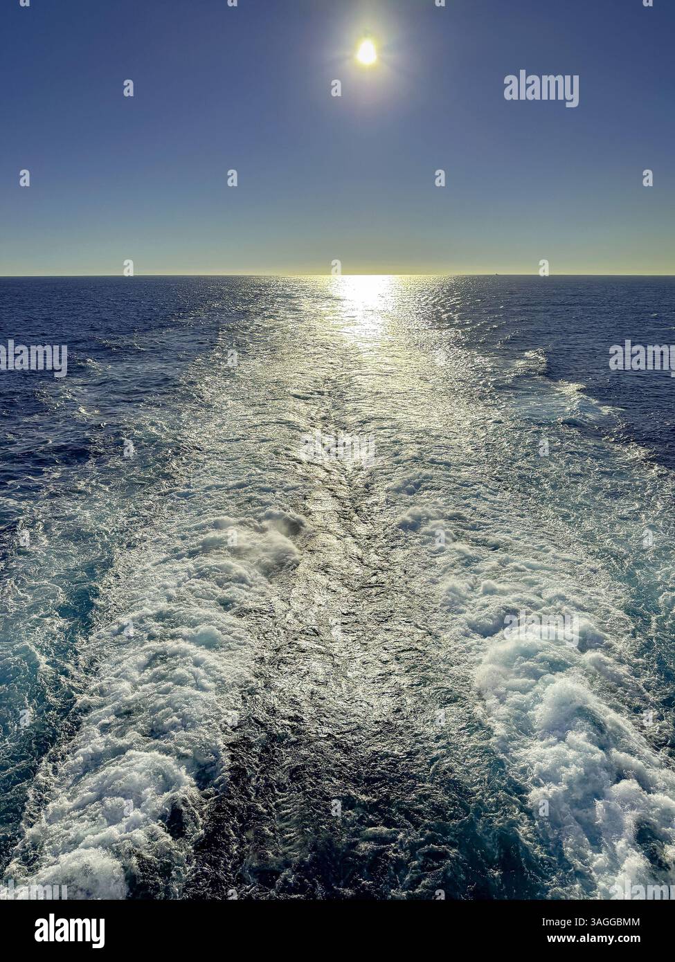 Seascape  of the wake of a cruise ship with the sun low over the horizon. Cruise vacation concept. No people.low sun - Smartphone Captured Stock Image