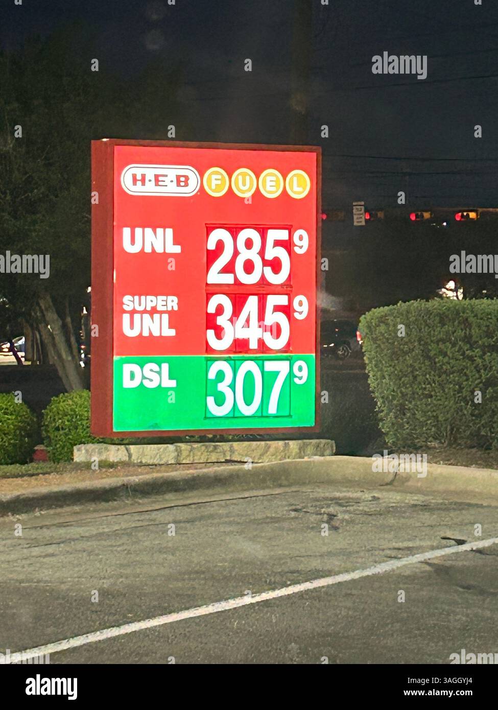 Street sign in front of gas petrol filling station with fuel prices - Smartphone Captured Stock Image