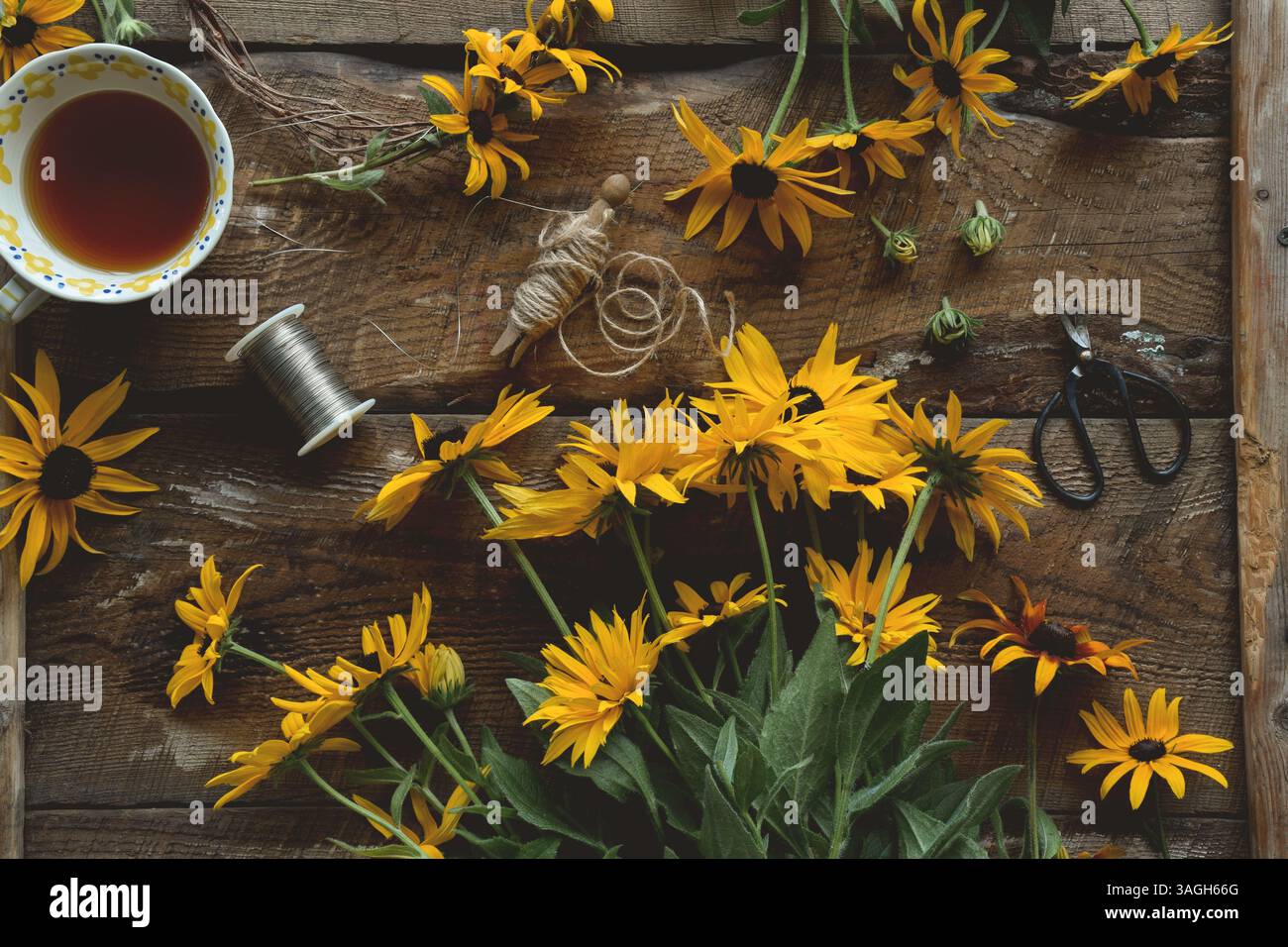 Overhead shot of yellow flowers on rustic wooden table Stock Photo
