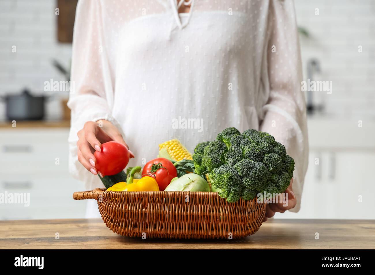 Pregnant woman holding wicker basket with different fresh vegetables in ...