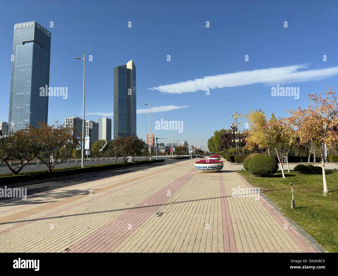 Modern skyscrapers line a city street on a bright, sunny day with a clear blue sky. - Smartphone Captured Stock Image