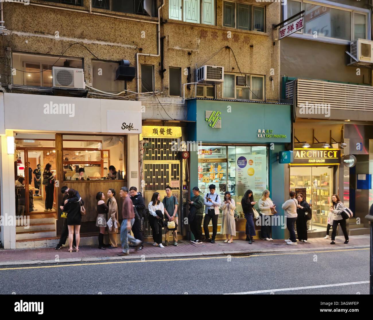 A long line of customers at the Sofi Pasta Co. restaurant on Bonham Strand in Sheung Wan, Hong Kong. - Smartphone Captured Stock Image