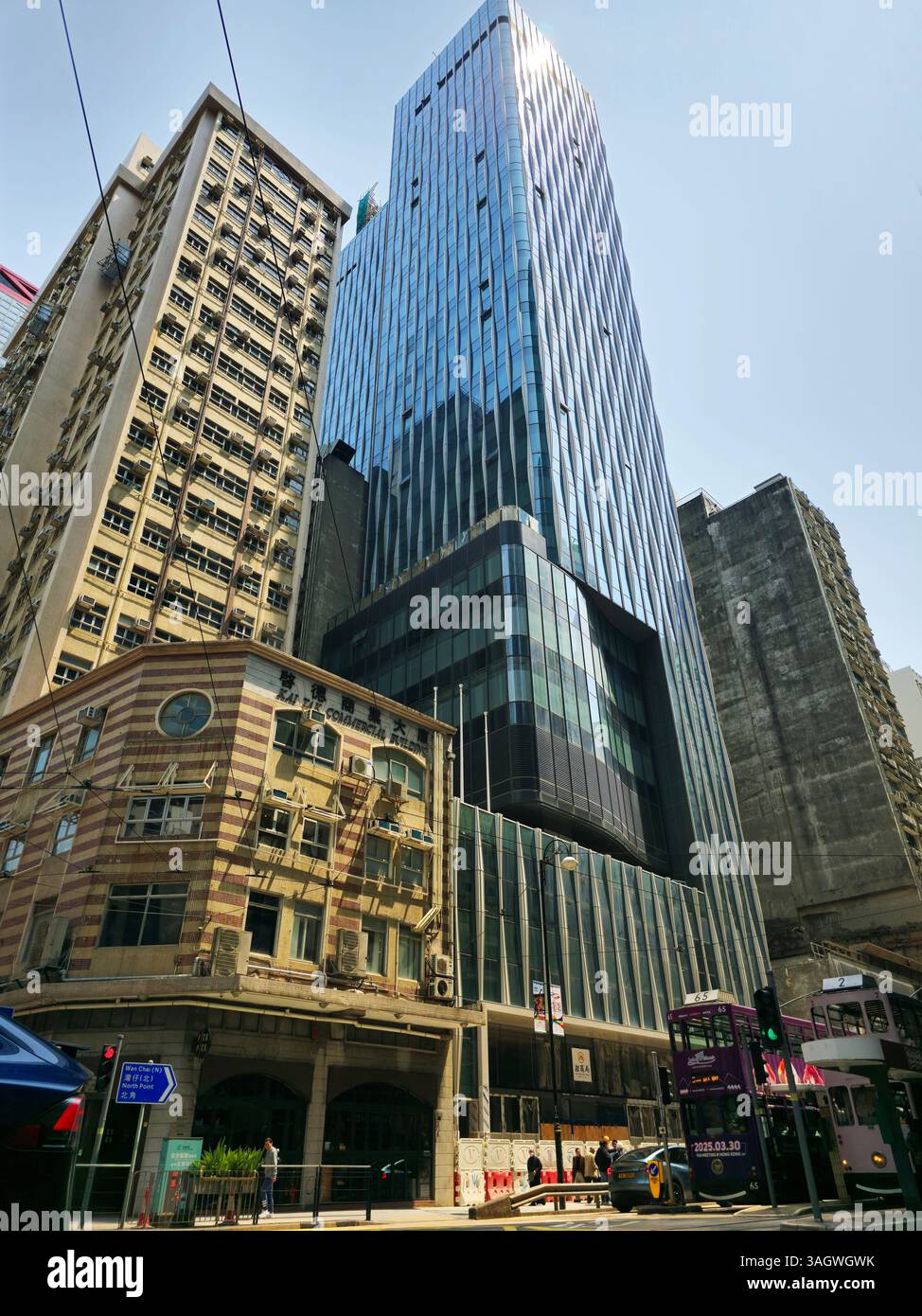 A newly built modern skyscraper next to the old Kai Tak Commercial building on Des Voeux Rd Central in Sheung Wan, Hong Kong. - Smartphone Captured Stock Image