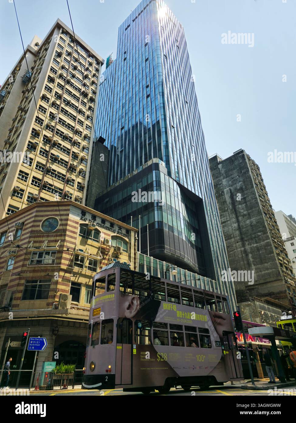 A newly built modern skyscraper next to the old Kai Tak Commercial building on Des Voeux Rd Central in Sheung Wan, Hong Kong. - Smartphone Captured Stock Image
