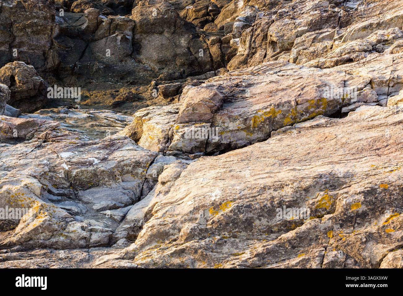 natural sea rock texture. outdoor background of sandstone surface in morning light. rustic seaside. closeup of rough stone on coast terrain Stock Photo