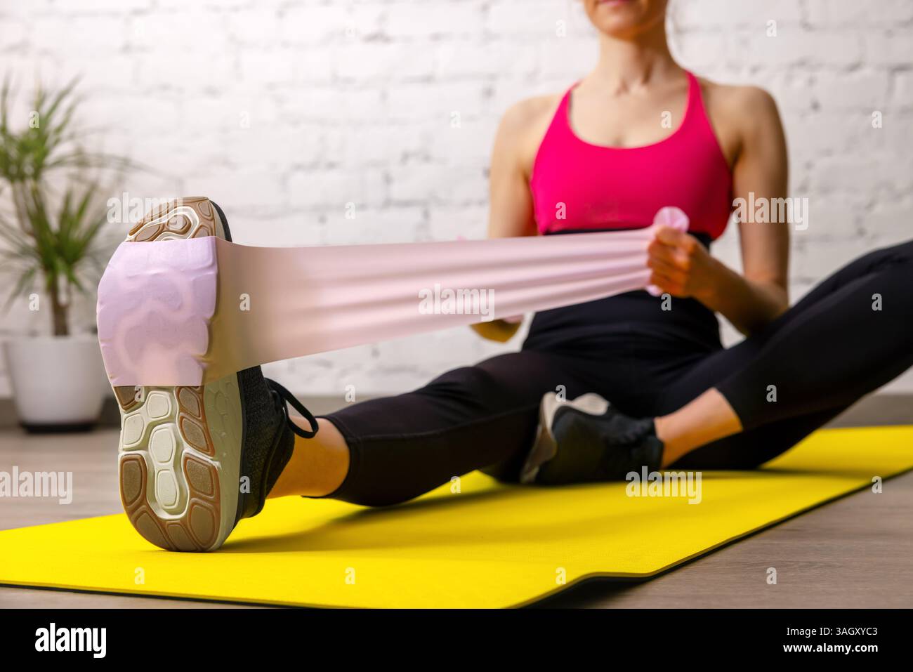fitness woman exercising with resistance bands on mat in gym. muscle strength and stretching workout Stock Photo