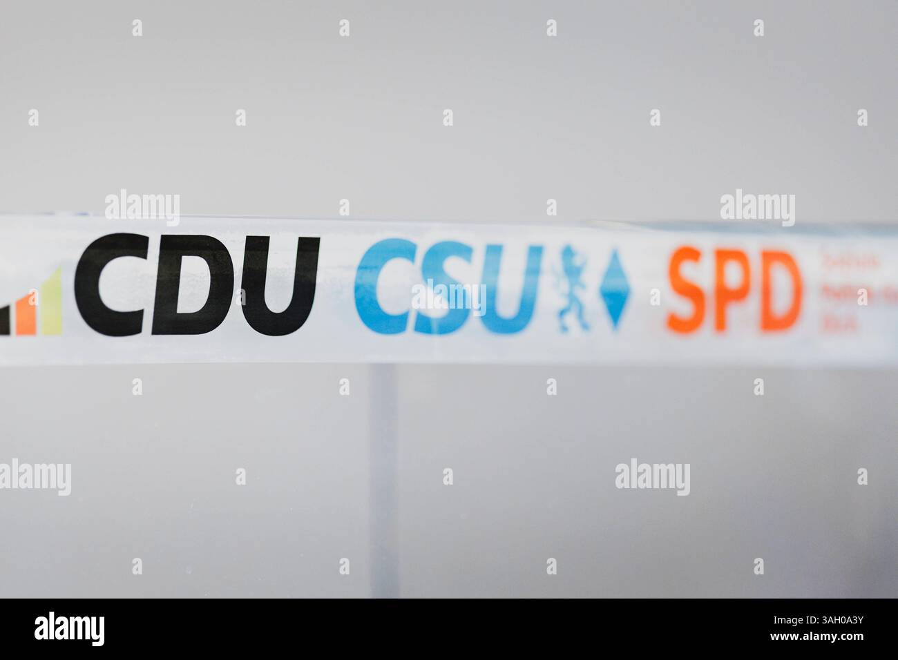 Das Rednerpult wird mit den Parteilogos von CDU, CSU und SPD ...