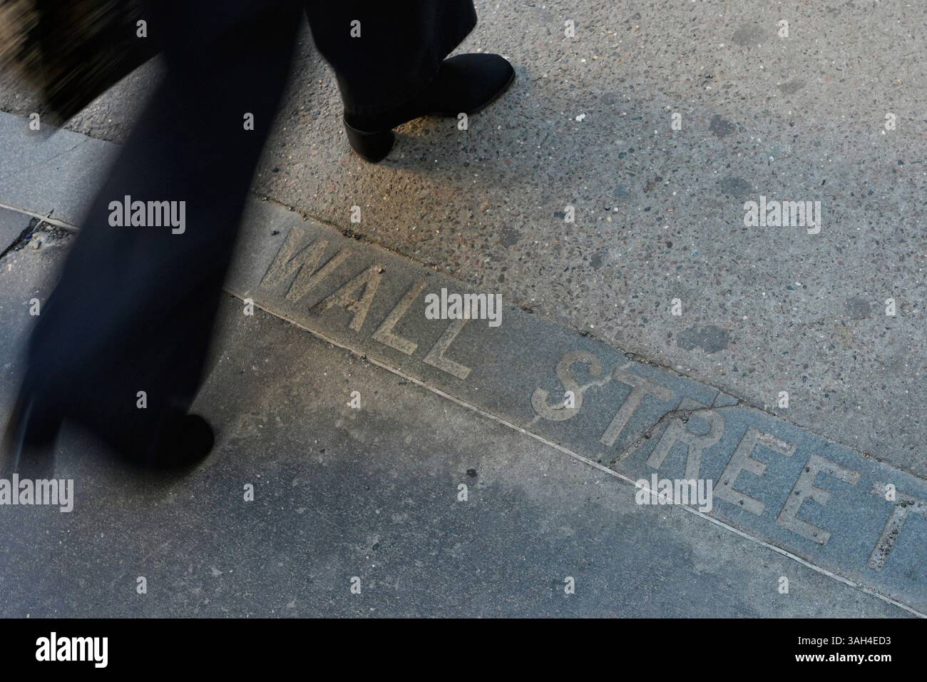 Pedestrians walk past a Wall Street sign on the sidewalk near the New ...