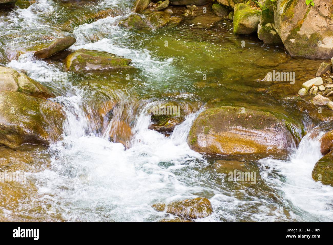 rapid water stream among rocks and stones. beautiful nature background in romanian mountains. closeup view from above Stock Photo