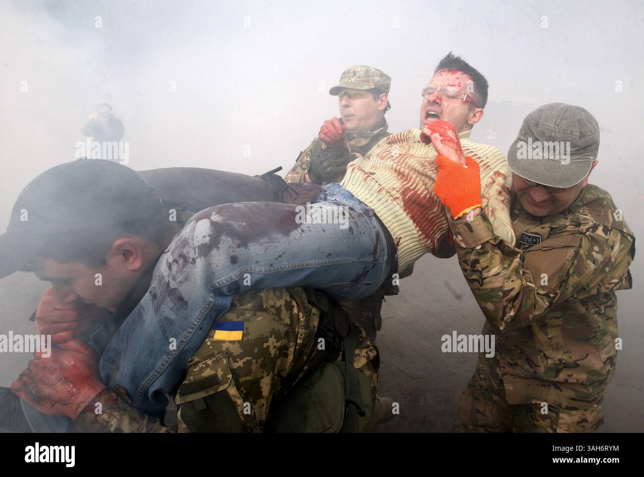 March 31, 2015 - Kiev, Ukraine - Kiev officials and volunteers carry a mock victim during a training session with tactical medicine for civilians on a shooting range outside of Kiev, Ukraine, 31 March 2015.For participants simulate real situations and providing emergency medical care and civil defence in emergency situations  (Credit Image: © Serg Glovny/ZUMA Wire/ZUMAPRESS.com) Stock Photo