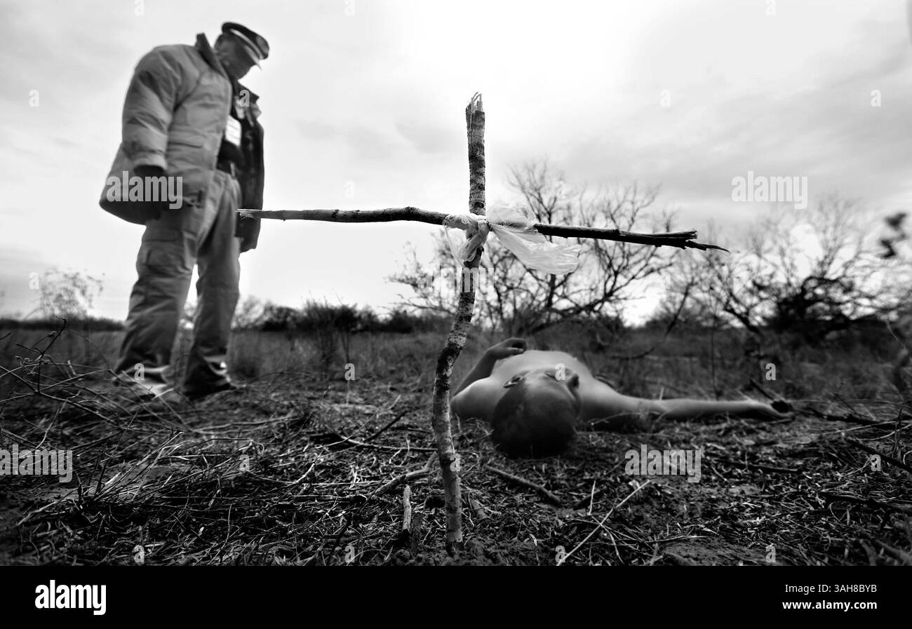 Jan. 29, 2014 - Falfurrias, Texas, U.S. - Rafael Hernandez, director of Angeles del Desierto stands over the body of an undocumented immigrant, after placing a cross he made of broken twigs.  Hernandez came across the body while searching on a ranch just outside Falfurrias, Tx. The death witnessed by a handful in South Texas was a precursor to the record number of Central American immigrants that were apprehended in 2014. (Credit Image: © San Antonio Express-News/ZUMA Wire) Stock Photo