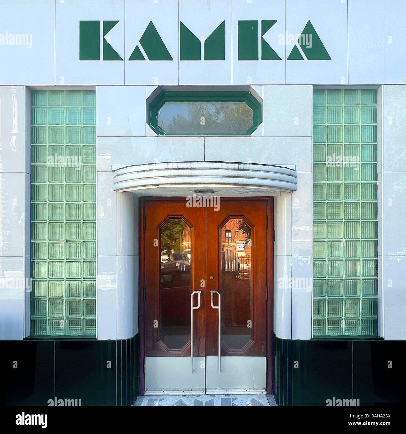 Streamline Moderne facade with geometric glass blocks and bold typography above double doors in Chicago. Timeless Art Deco elegance. - Smartphone Captured Stock Image