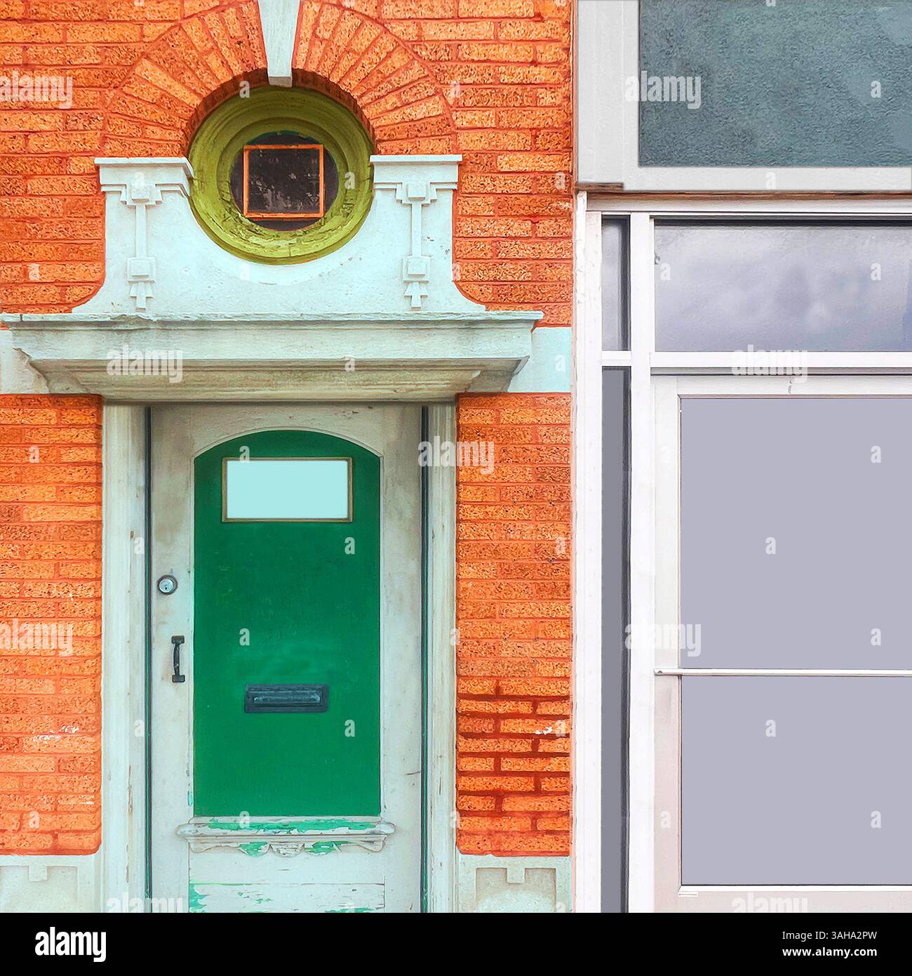 Green door set in an ornate limestone frame beneath a circular window with a green trim, contrasting against vibrant orange brick in a Chicago streets. - Smartphone Captured Stock Image