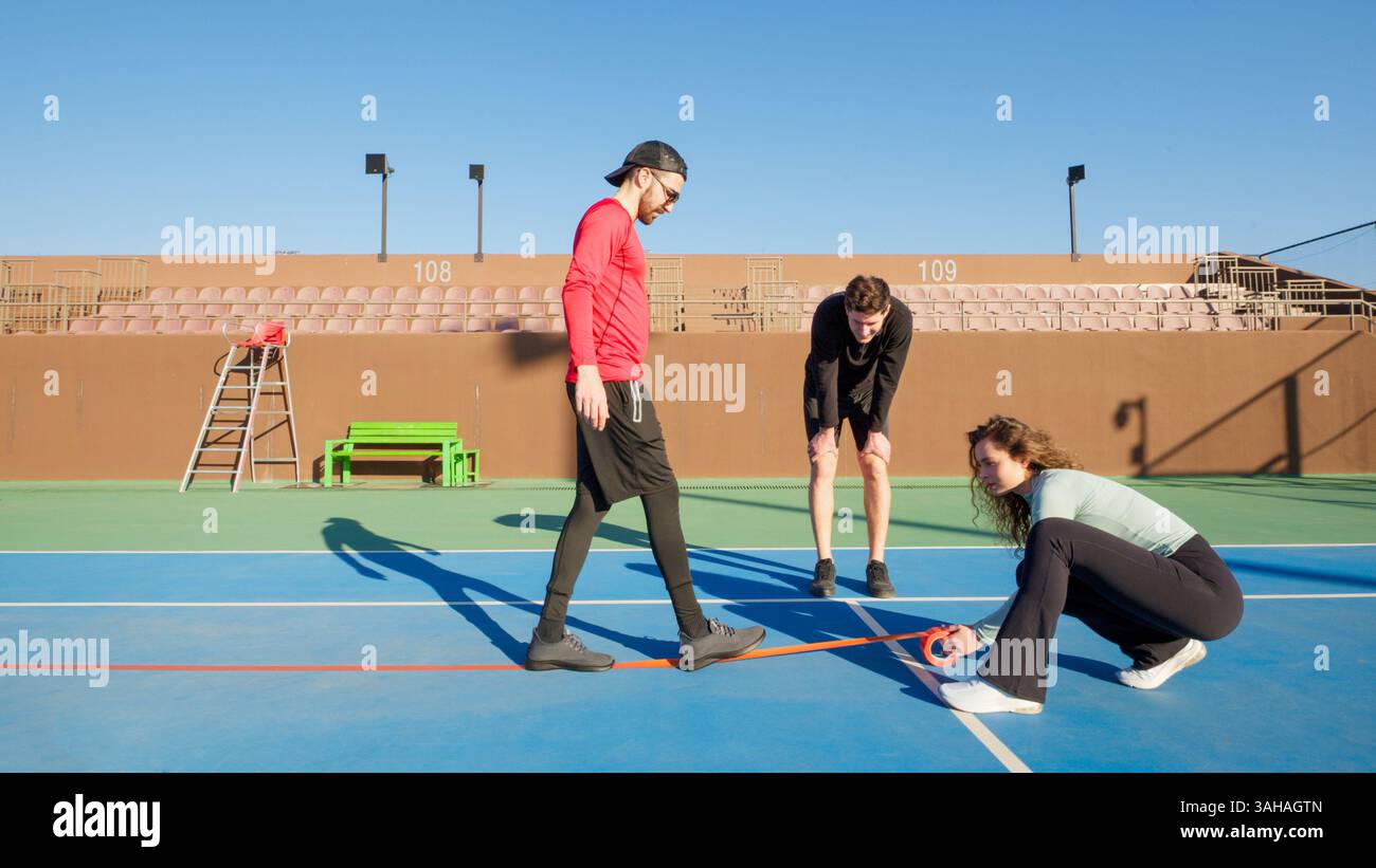 Group of youngfriends converting a Tennis court to a Pickleball