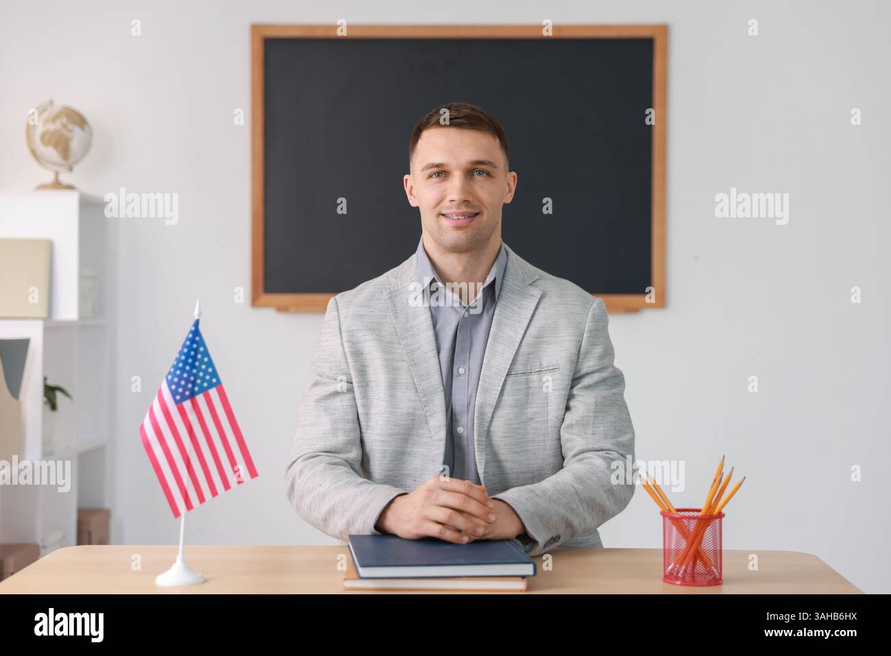 English teacher working at desk in classroom Stock Photo - Alamy