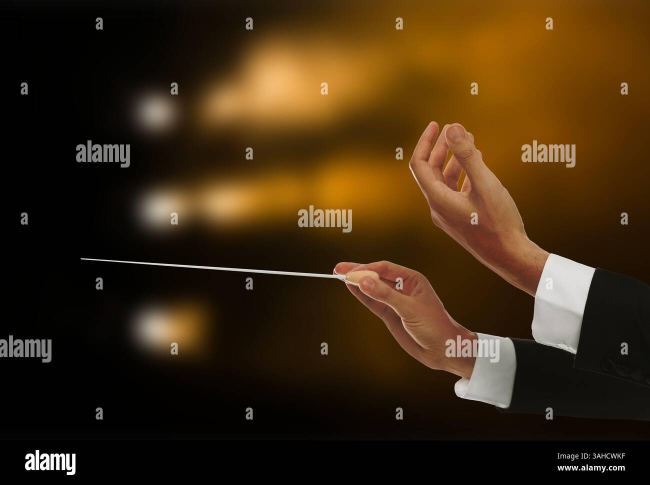 Conductor directing orchestra with baton in concert hall, closeup Stock ...