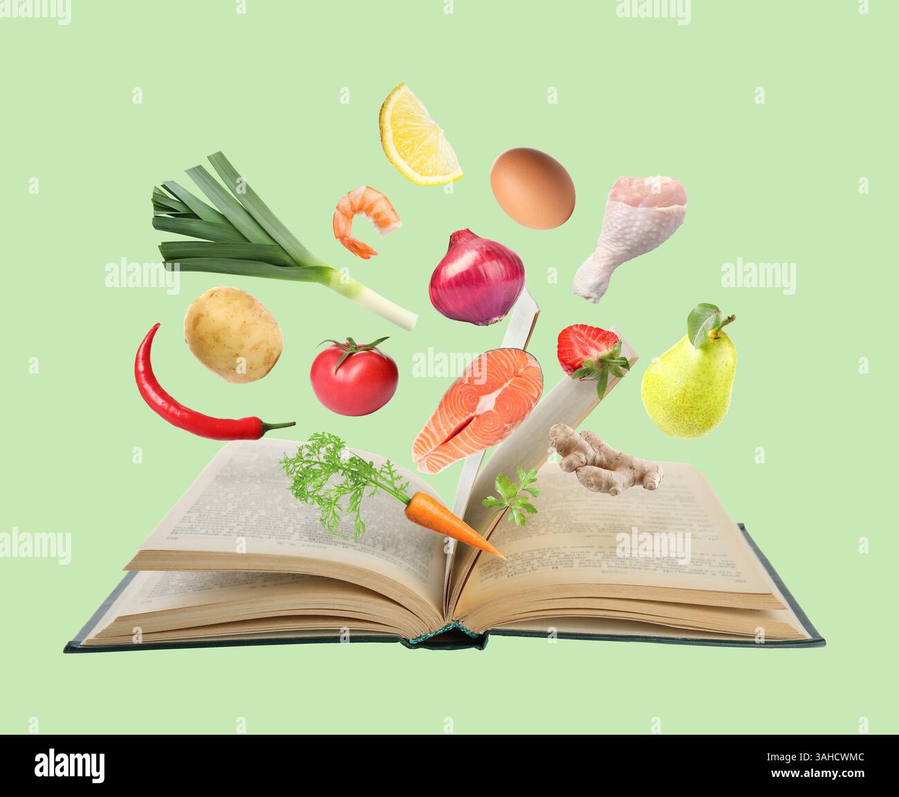 Fresh ingredients in air over recipe book on light green background Stock Photo