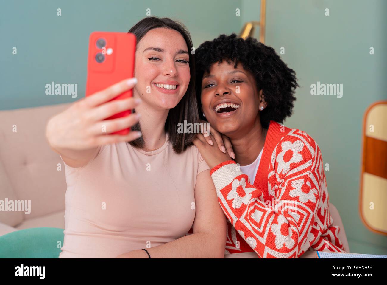 African American and Caucasian students taking selfie while studying at home Stock Photo