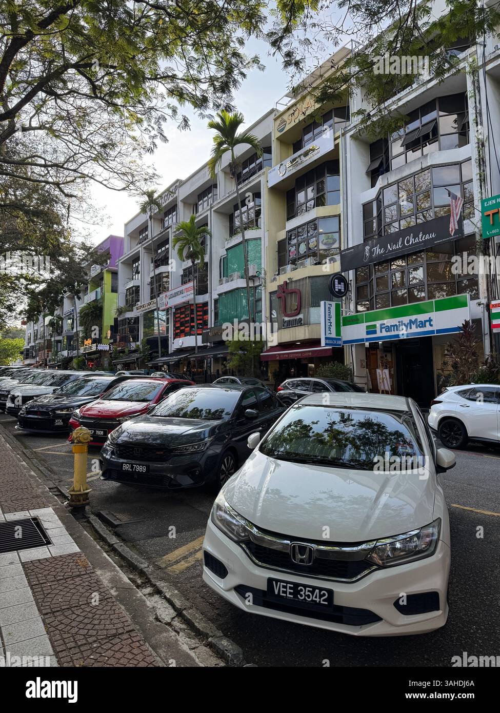 Colorful shopping strip at Damansara, Malaysia, viewed from the carpark. Vibrant urban retail scene with bold shopfront facades. Stock Photo