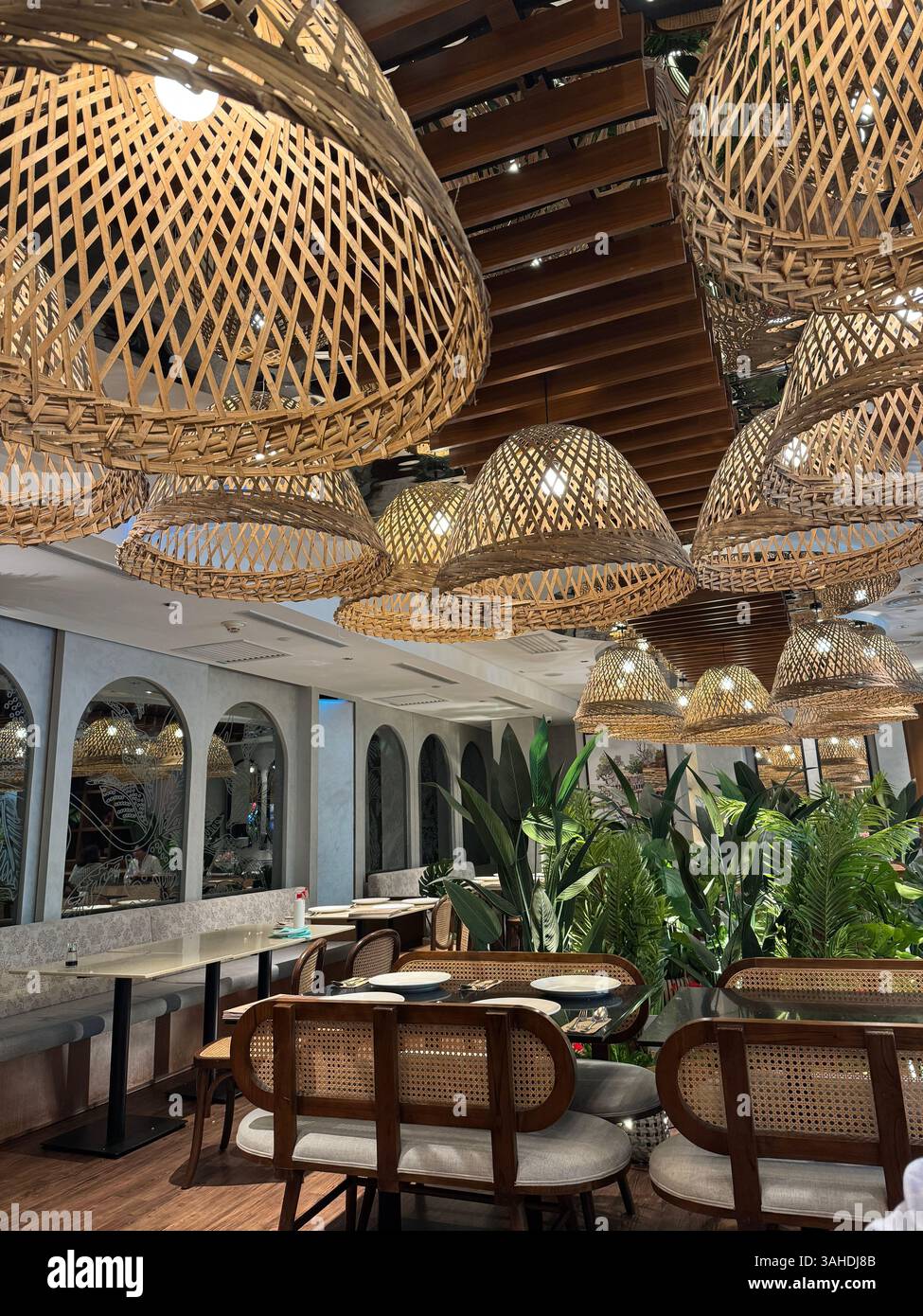 Woven basket-style lightshades in a Malaysian restaurant at KLCC, Kuala Lumpur. Warm lighting meets traditional design. - Smartphone Captured Stock Image