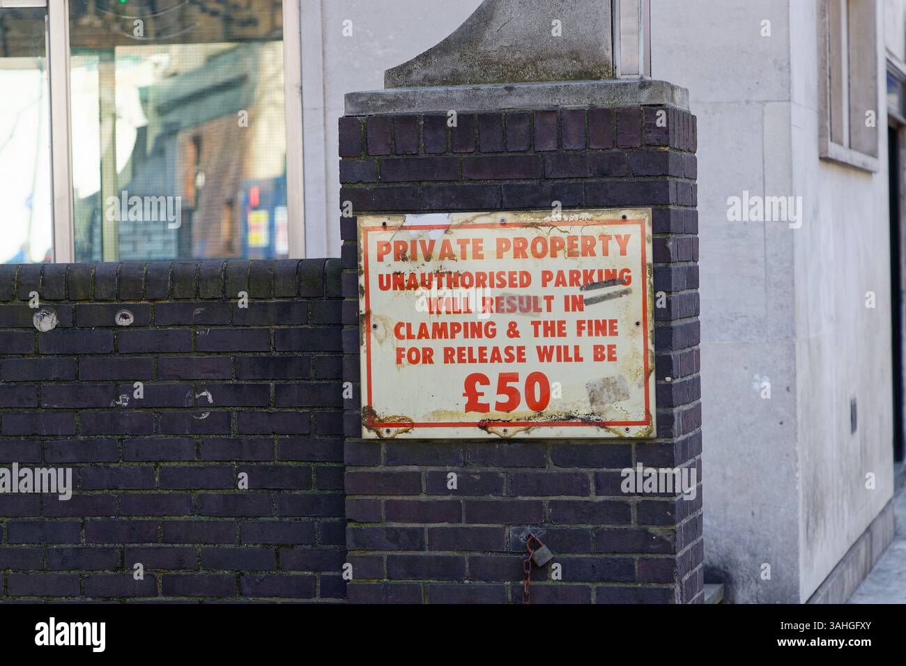 A Private Property sign, saying or warning that any unauthorised parking will result in vehicle clamping & a fine of £50 for release. Stock Photo