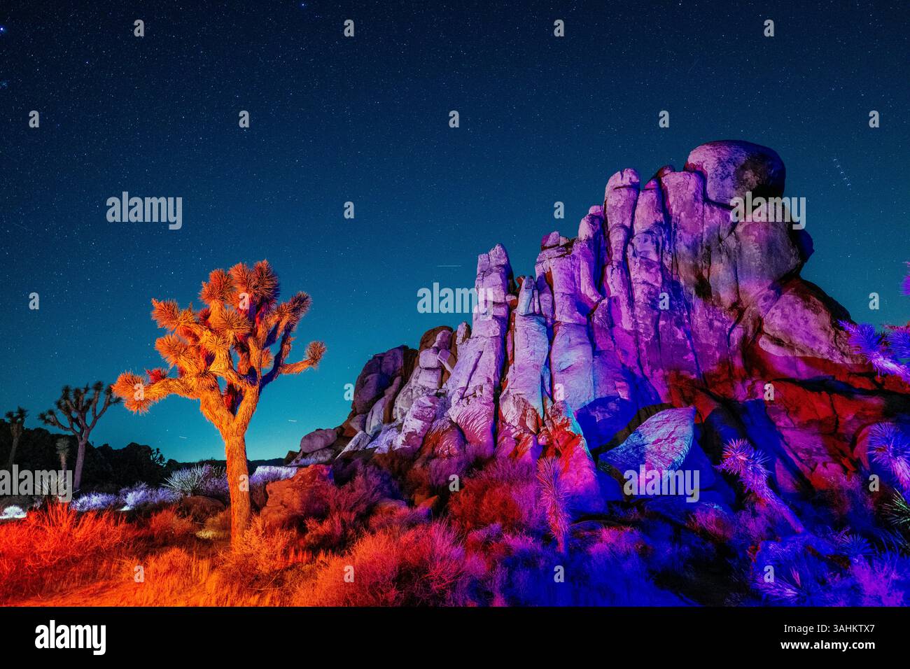 Colorful desert landscape at night with illuminated rock formations and ...