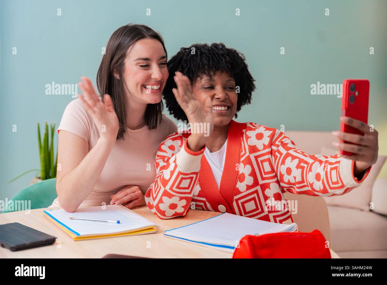 African American and Caucasian students taking selfie while studying at home Stock Photo
