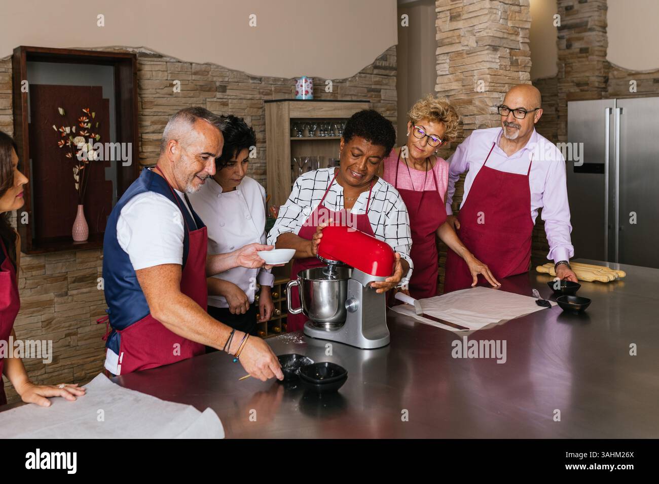 Chefs using stand mixer preparing dough in cooking class Stock Photo