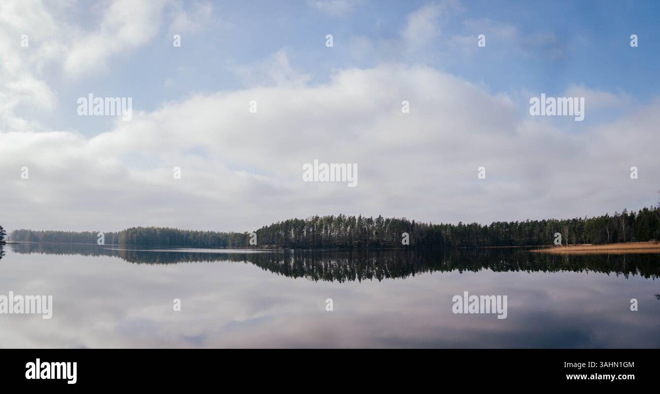 A serene lake in Sweden, featuring an island surrounded by lush trees ...