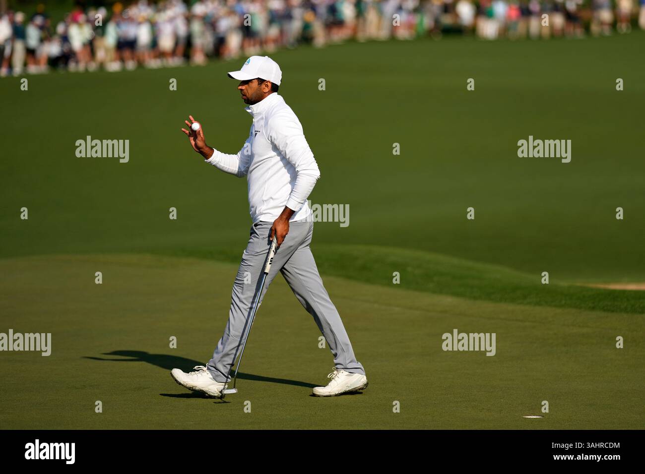 Aaron Rai, of England, waves after making a putt on the second hole ...