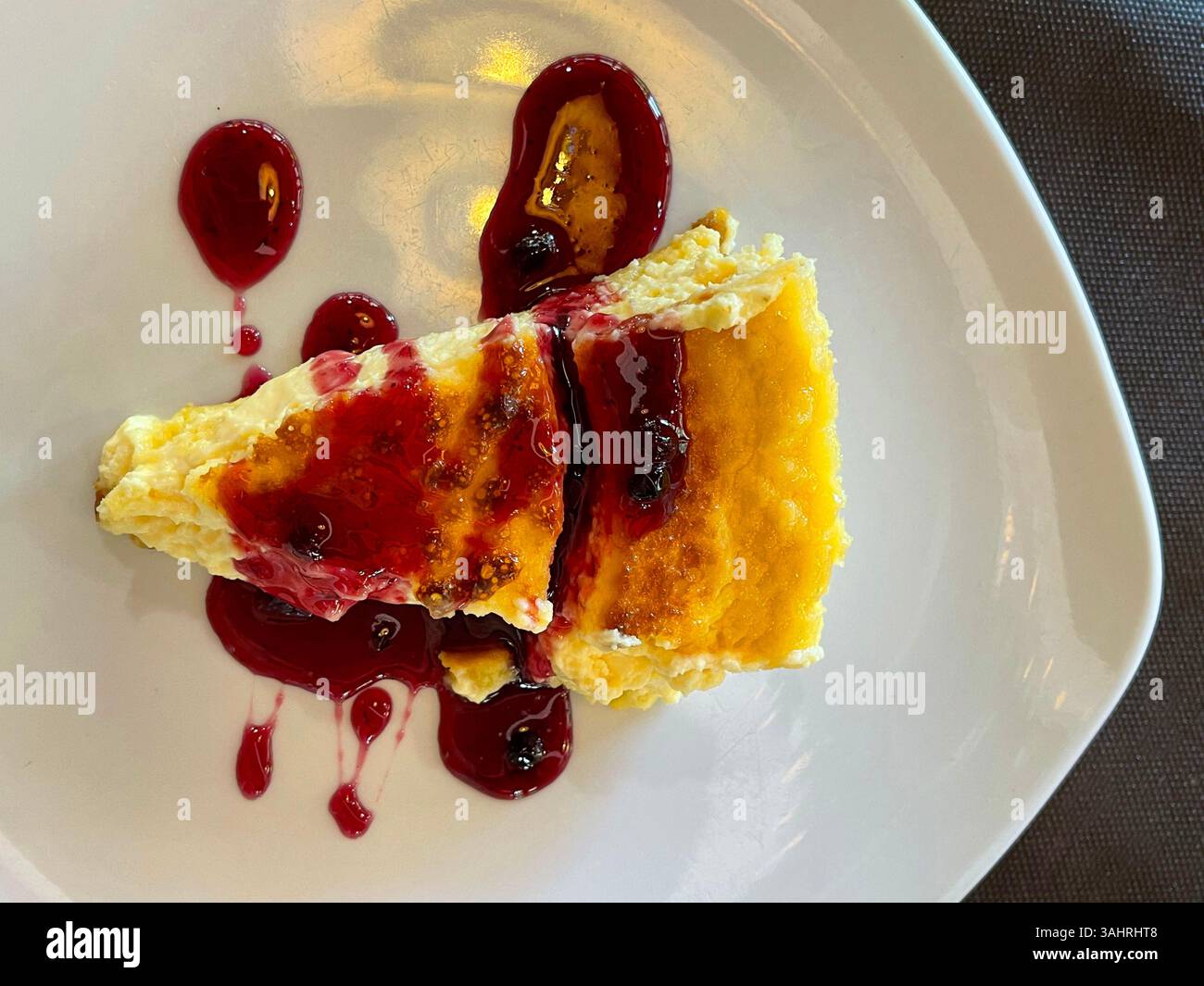 Cheese cake with raspberry syrup. Spain. - Smartphone Captured Stock Image