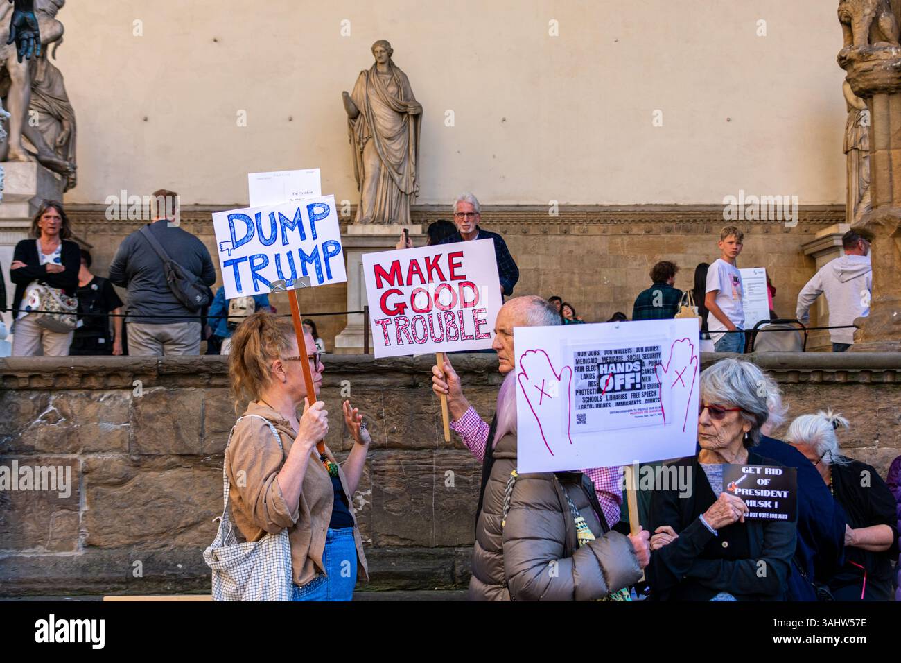 'Hands Off!' protest at Piazza della Signoria, Florence, opposing Trump and Musk’s DOGE policies, defending democracy and public services. Stock Photo