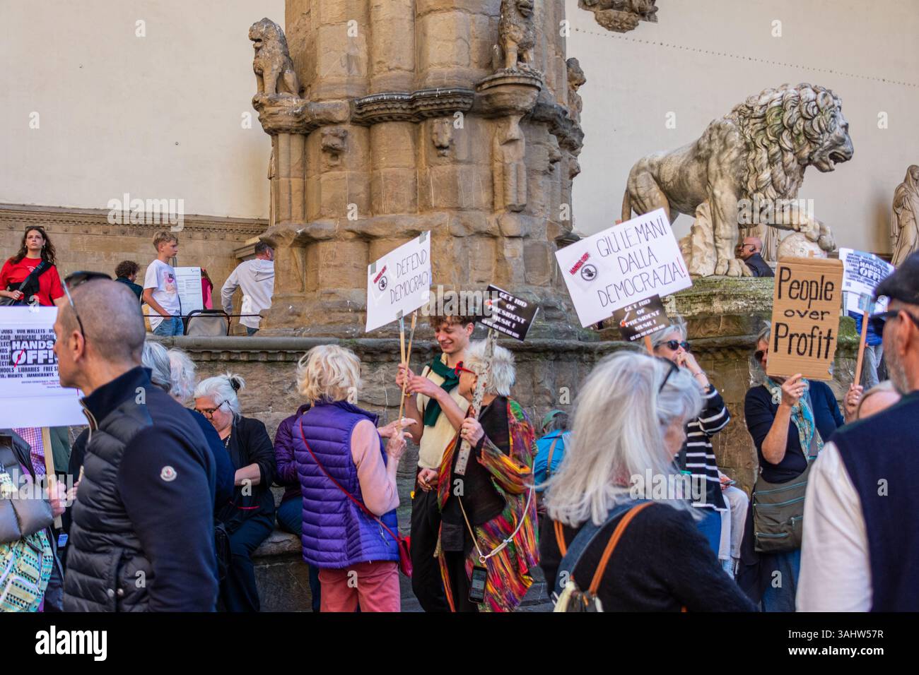 'Hands Off!' protest at Piazza della Signoria, Florence, opposing Trump and Musk’s DOGE policies, defending democracy and public services. Stock Photo