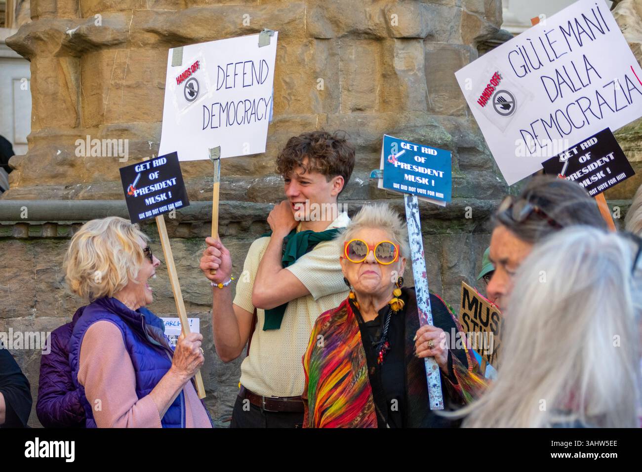 'Hands Off!' protest at Piazza della Signoria, Florence, opposing Trump and Musk’s DOGE policies, defending democracy and public services. Stock Photo