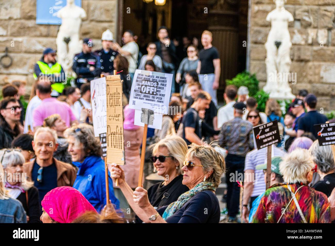 'Hands Off!' protest at Piazza della Signoria, Florence, opposing Trump and Musk’s DOGE policies, defending democracy and public services. Stock Photo