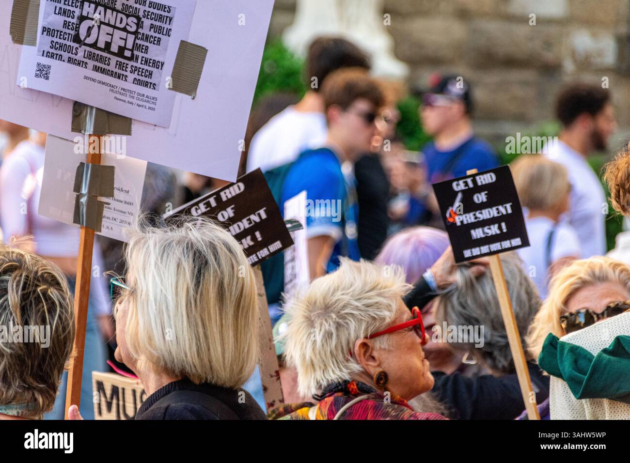 'Hands Off!' protest at Piazza della Signoria, Florence, opposing Trump and Musk’s DOGE policies, defending democracy and public services. Stock Photo