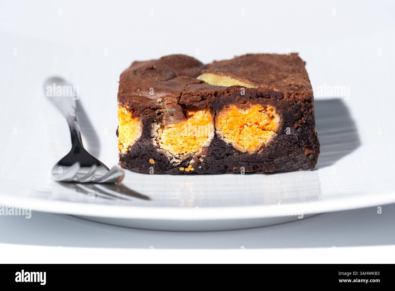 UK. A mint aero and orange aero chocolate brownie served on a plate. The brownie is plated and served with a pastry fork Stock Photo