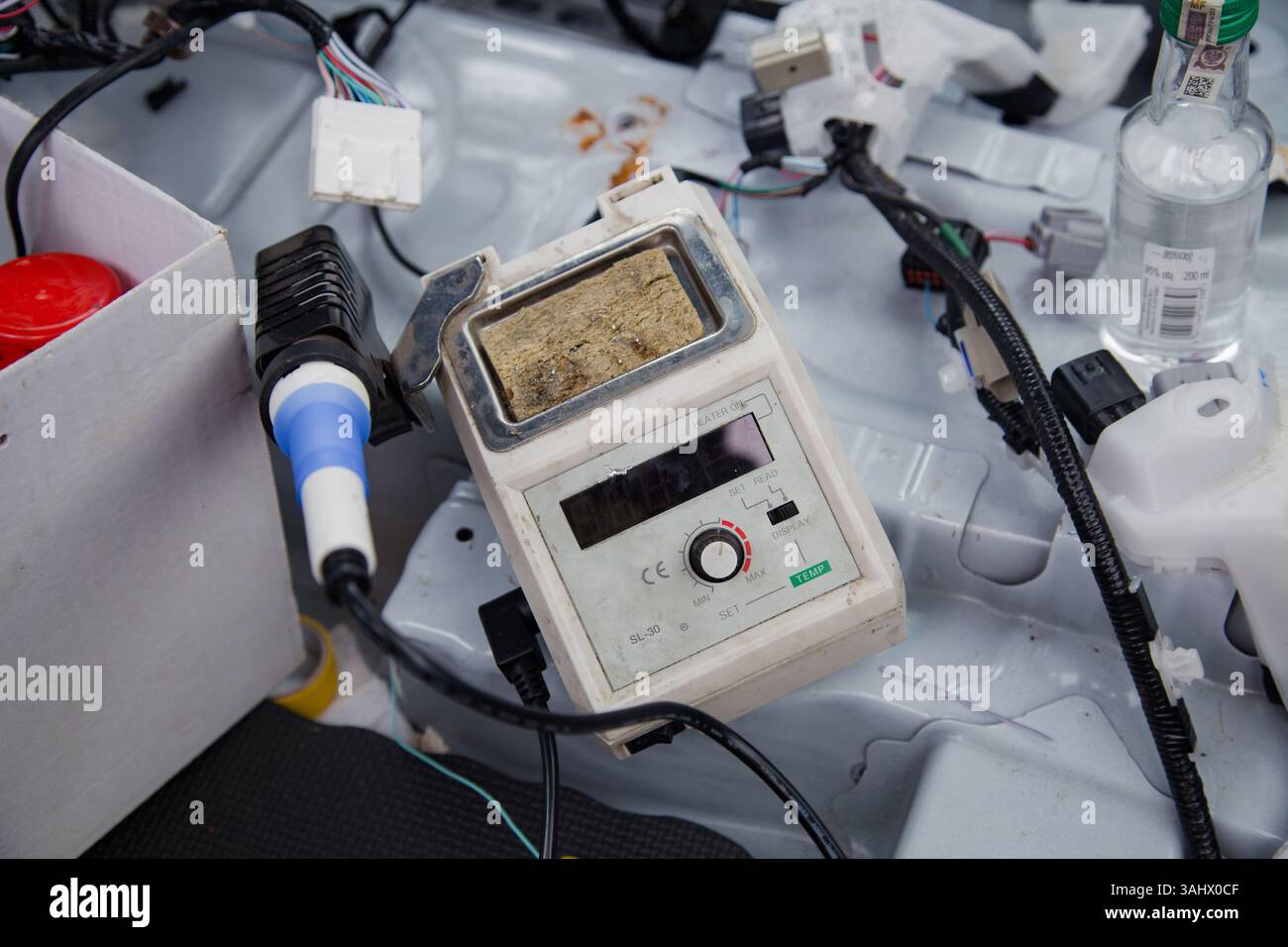 An old temperature-controlled soldering iron, set up and ready among