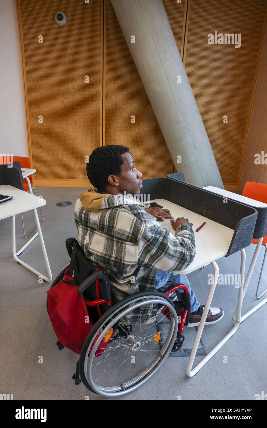 Man in wheelchair sitting in office Stock Photo