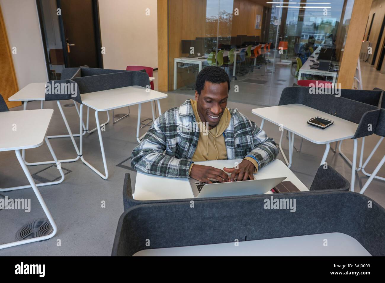 Man in wheelchair using laptop in office Stock Photo