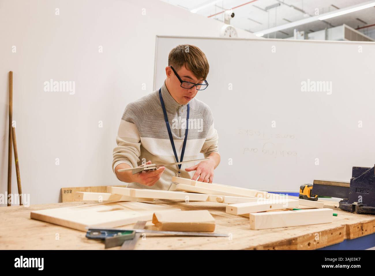 Man with Down Syndrome working in workshop Stock Photo