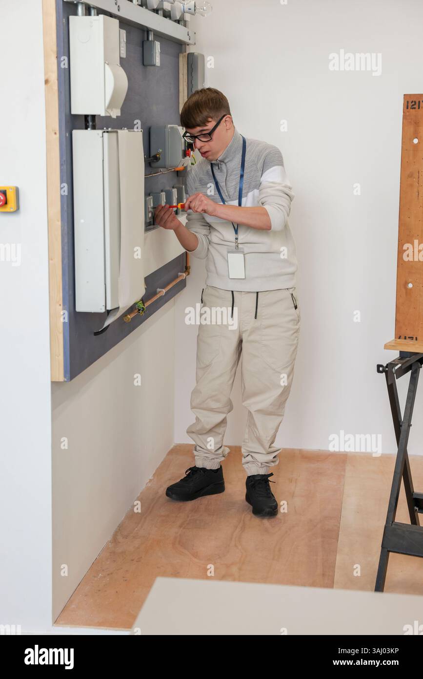 Man with Down Syndrome working in workshop Stock Photo