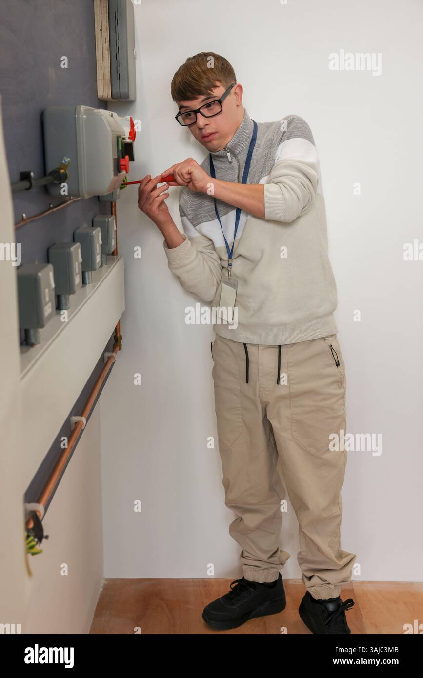 Man with Down Syndrome working in workshop Stock Photo