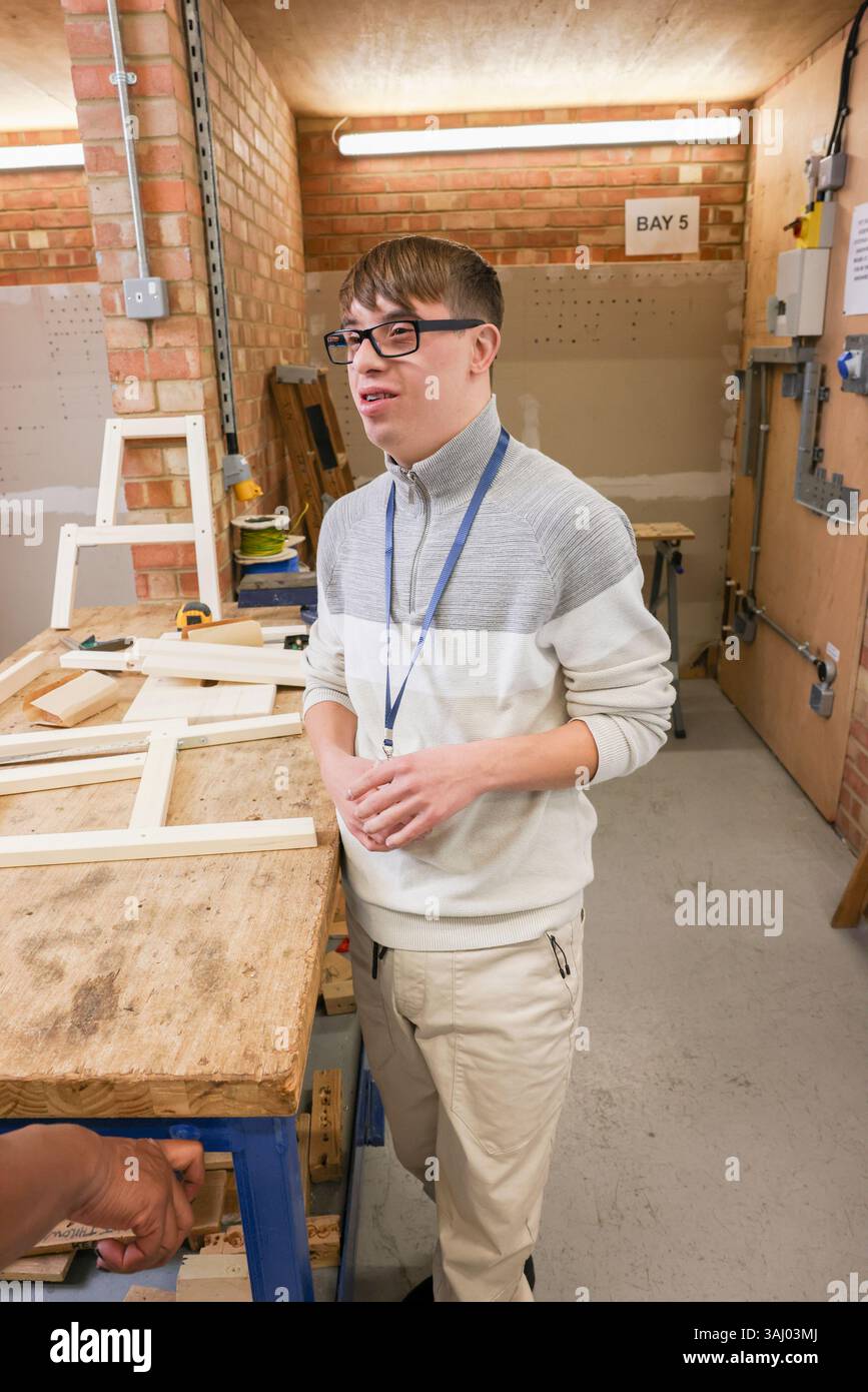 Man with Down Syndrome standing in workshop Stock Photo