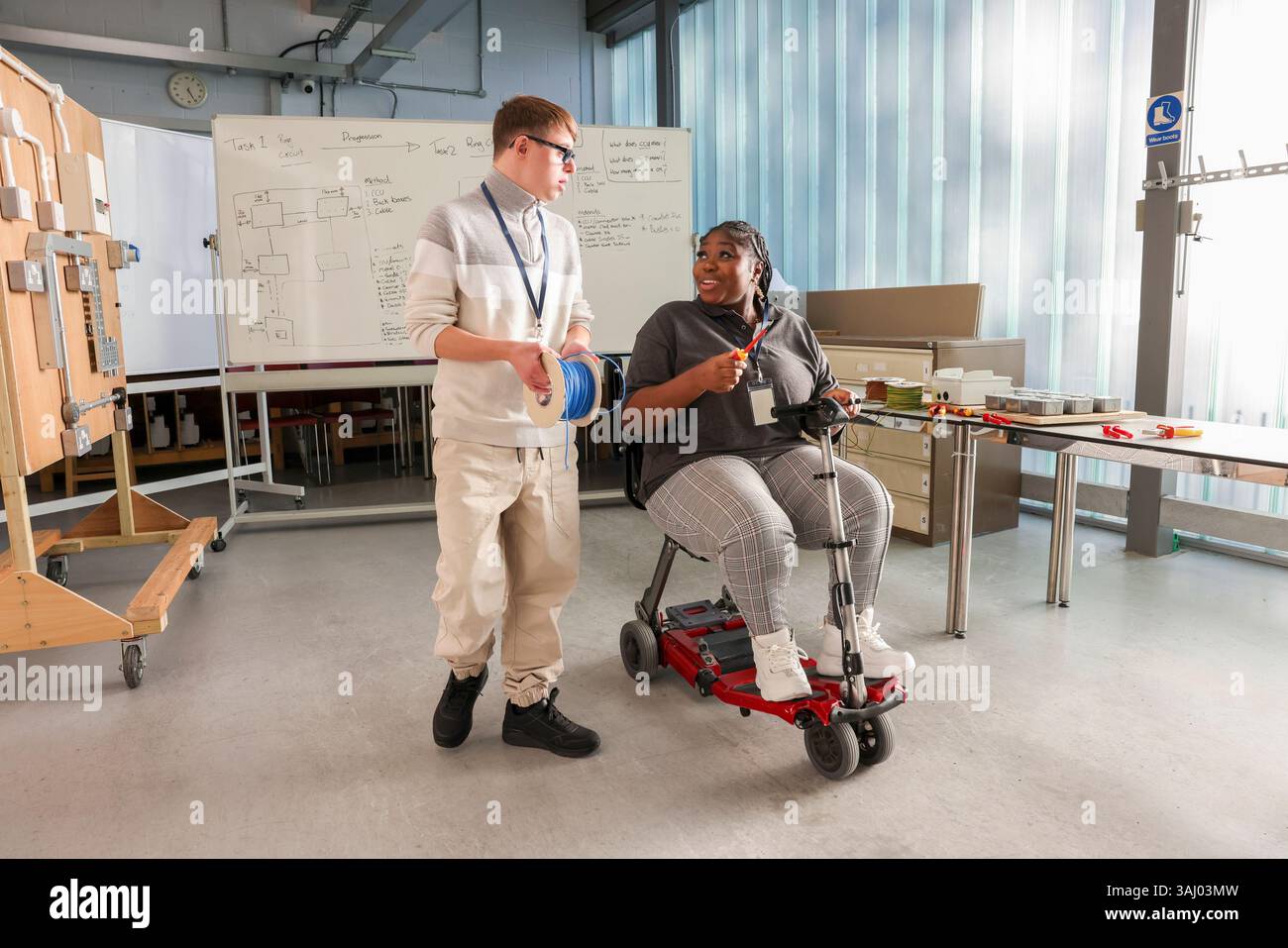 Disabled man and woman talking in workshop Stock Photo