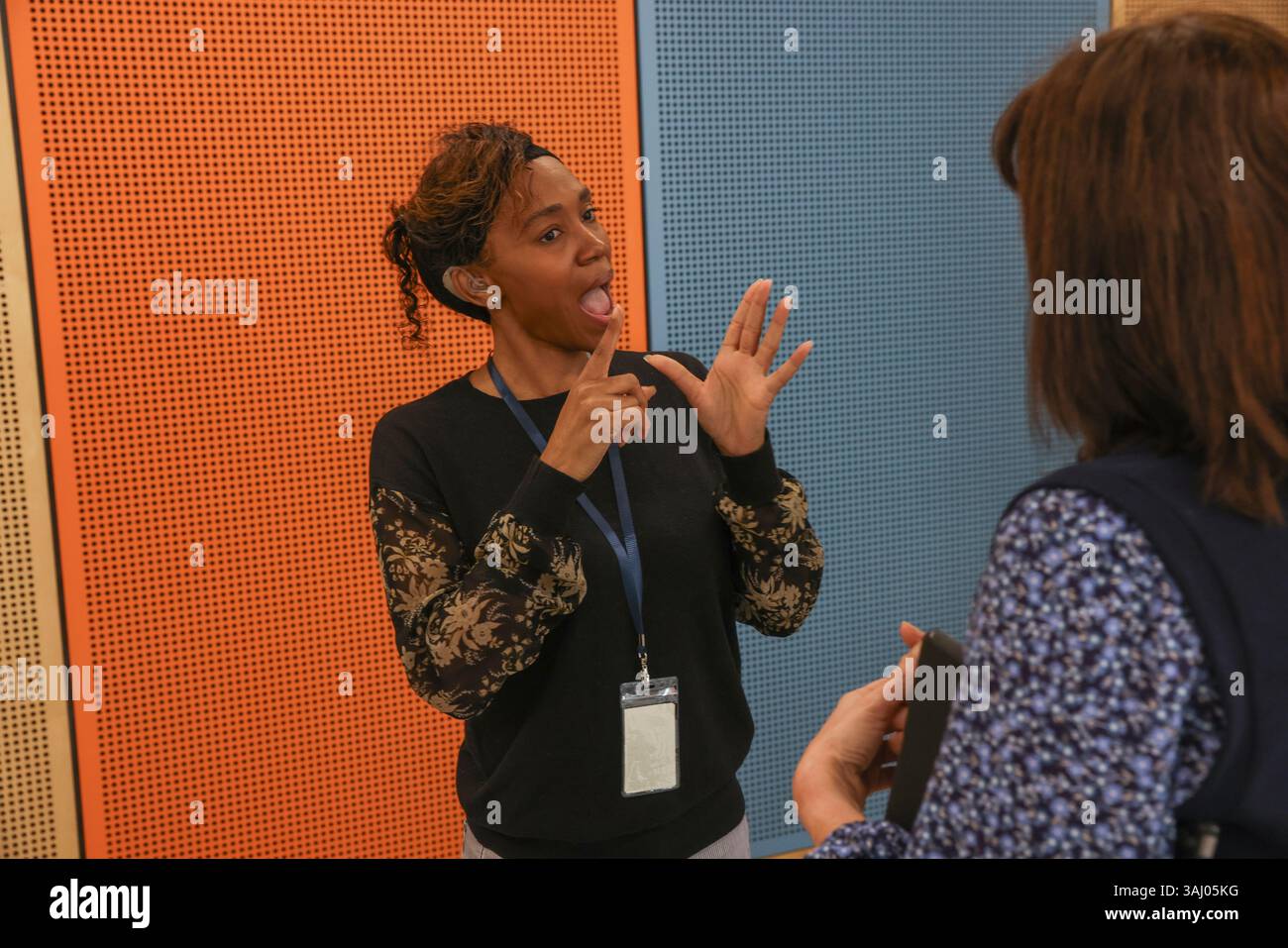Coworkers using sign language in office Stock Photo