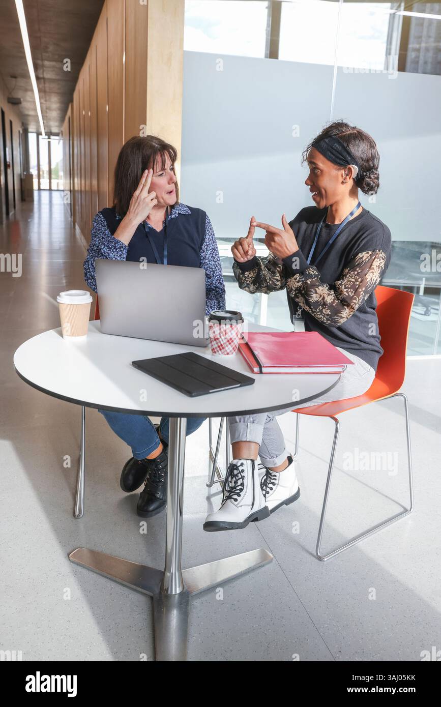 Coworkers using sign language in office Stock Photo