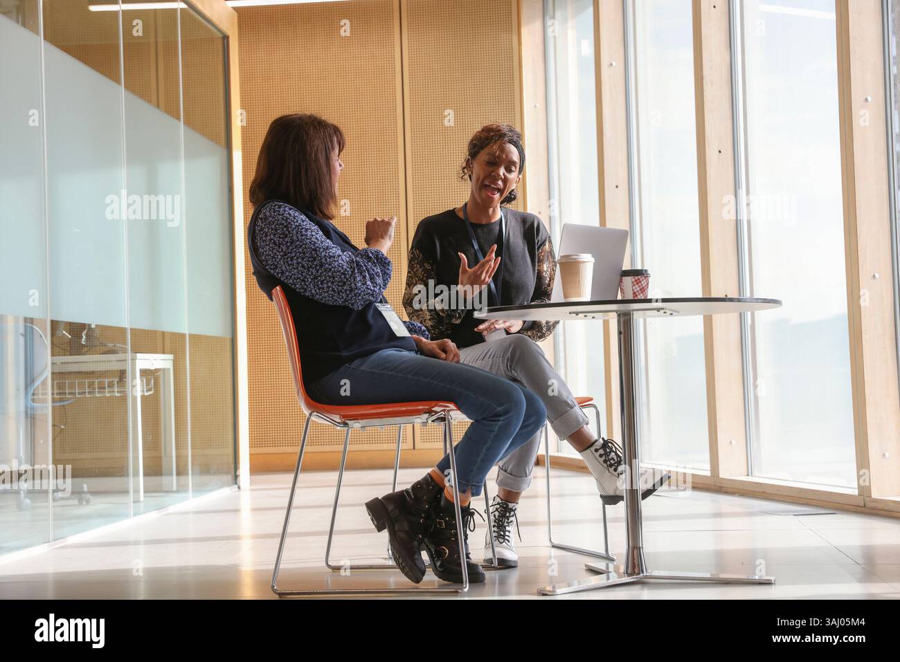 Coworkers using sign language in office Stock Photo