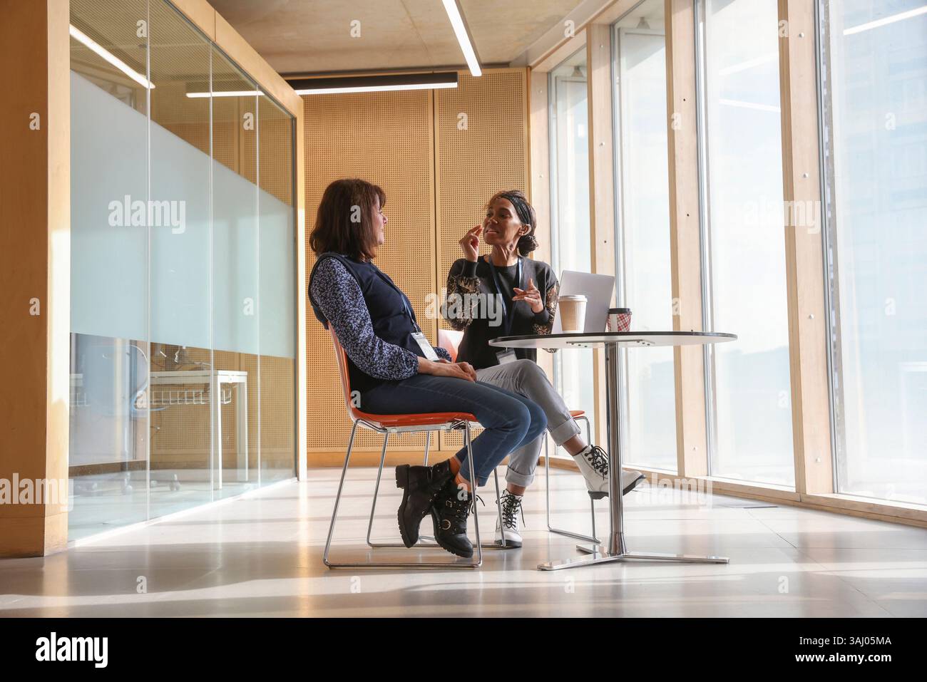 Coworkers using sign language in office Stock Photo